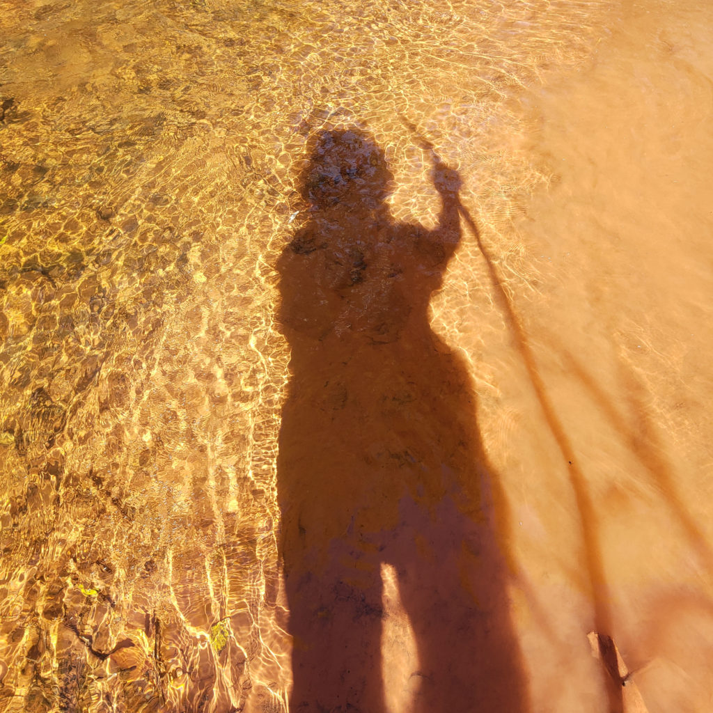 Shadow of a woman in a creek bed